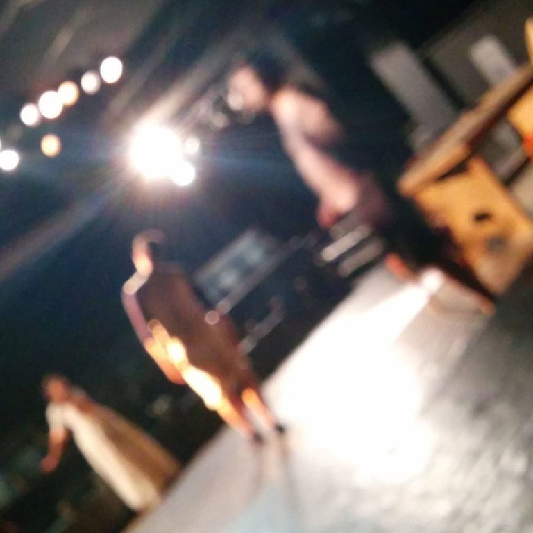 Cours de théâtre : masque de théâtre doré posé sur un fauteuil de velours rouge