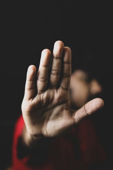 Harcèlement Harcèlement : main levée en signe de stop devant le visage d'un enfant